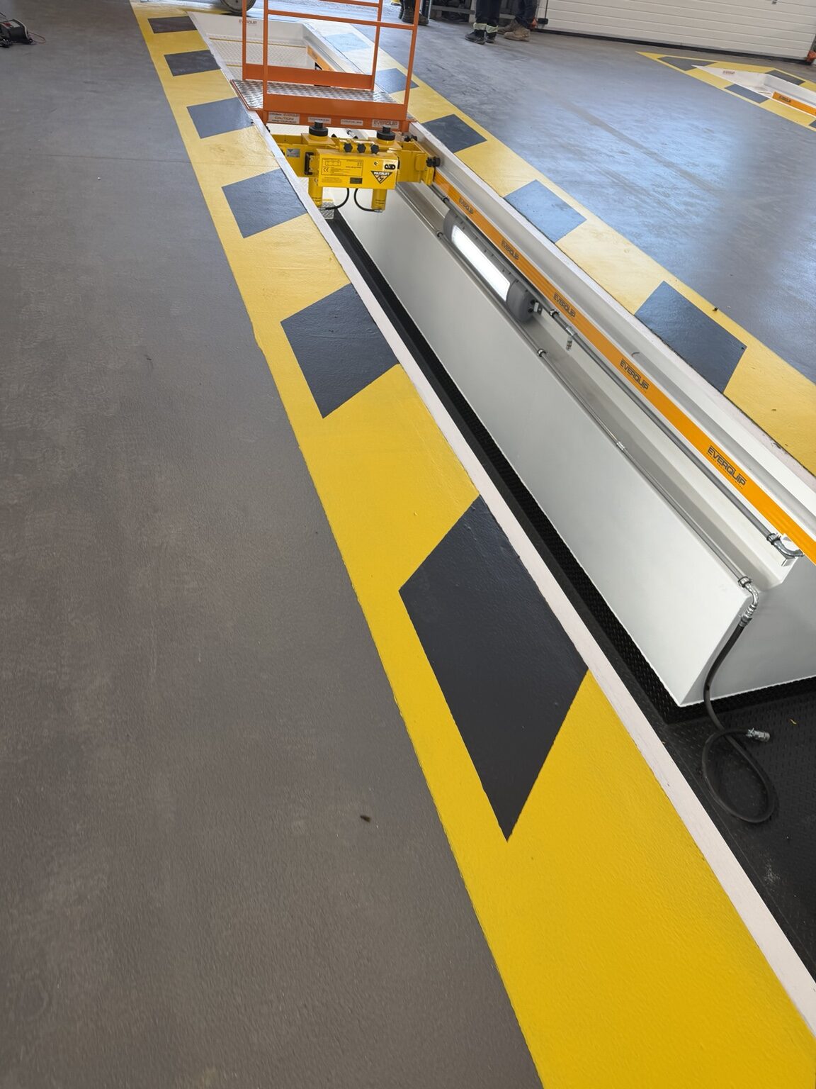 Grey industrial resin floor with yellow safety markings